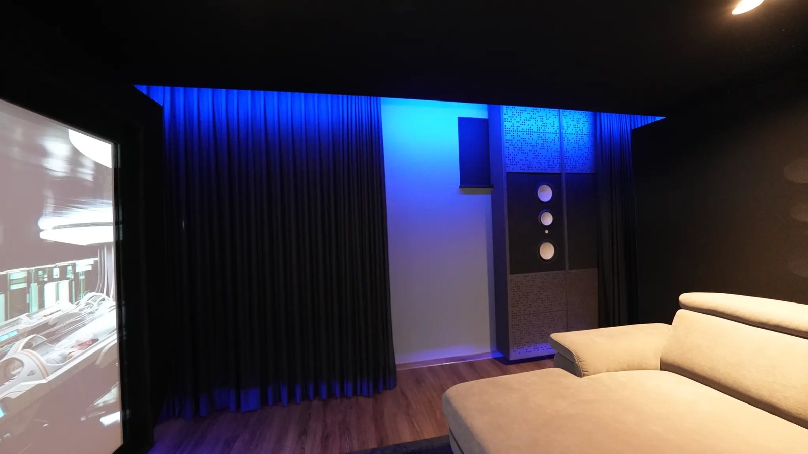 Dreiwege-Lautsprecher der Climax-Serie vor Akustikpanelen an der Wand, daneben der Bildrand der Leinwand.